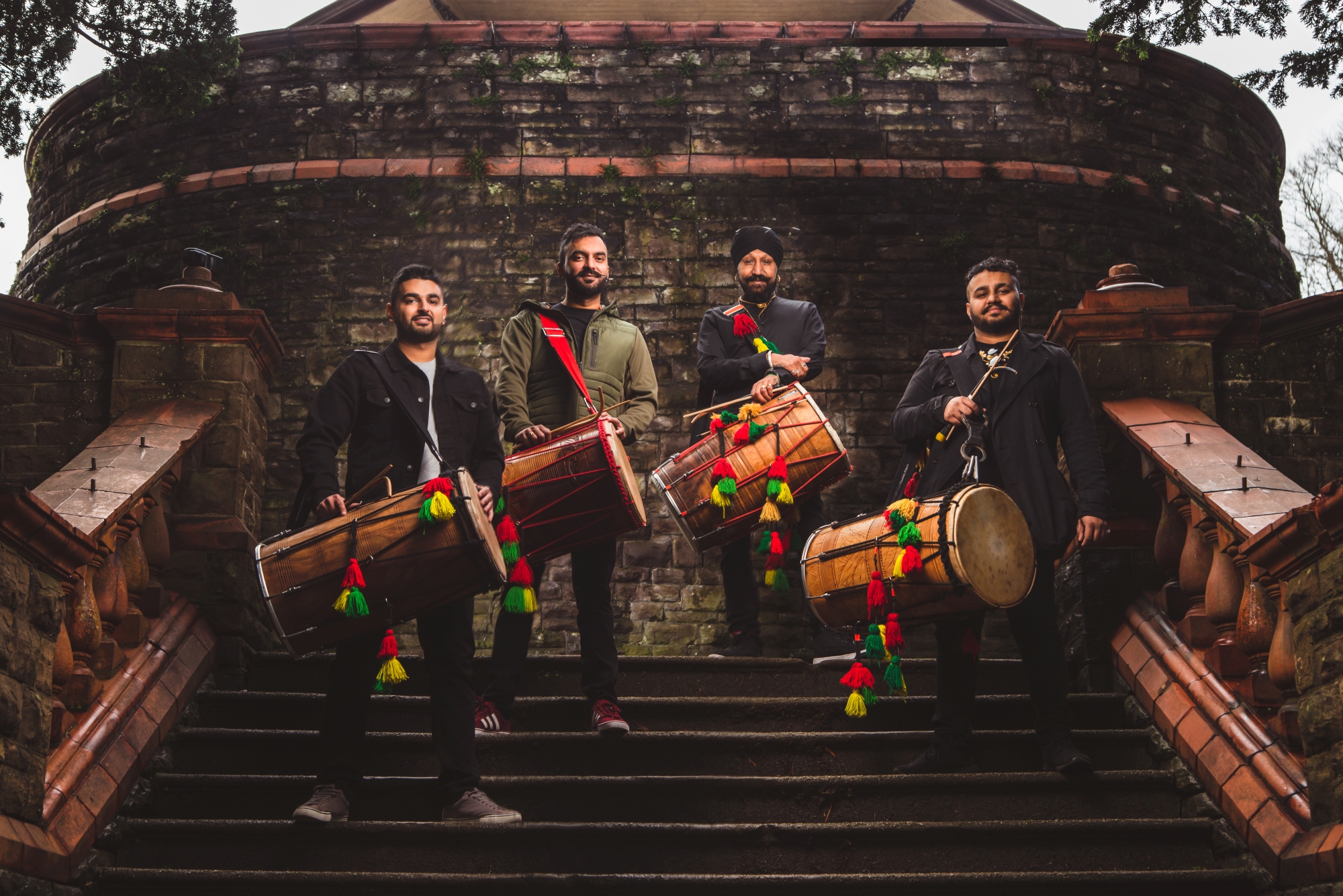 The band, stood with their dhols, on stone stairs, such as you'd see outside a stately home
